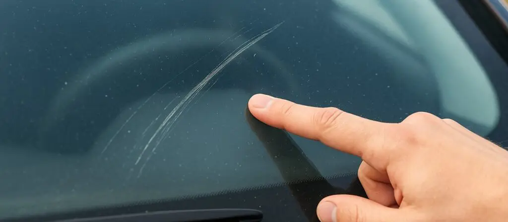 Rayure profonde sur une vitre de voiture avant réparation