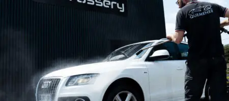 Homme entrain de laver un SUV Audi blanc en extérieur