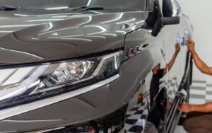 Carrossier appliquant un traitement céramique sur la porte arrière d'une voiture