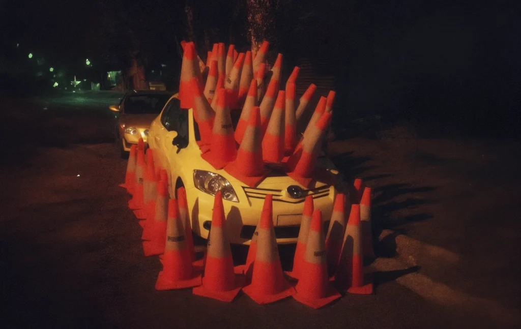 Photo d'une voiture avec des cones partout autour et sur elle